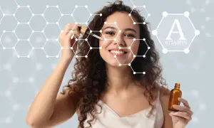 Kobieta z serum na twarzy, symbolizującym, jak działa retinol. W tle grafika przedstawiająca cząsteczki i witaminę A.