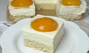 Pyszne ciasto jajko sadzone na biszkopcie, z kremem i brzoskwinią na wierzchu.