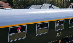 Pociąg retro PKP z pasażerami wyglądającymi przez okna. Sprawdzam pociąg retro rozkład jazdy.