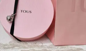 Caja rosa Tous con un charm de oso plateado colgando de un cordón negro. Ideal para tus colgantes Tous.