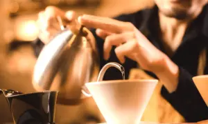 Barista häller upp varmt vatten för kaffe. Undrar hur hårt vatten har jag för att få bästa smak?