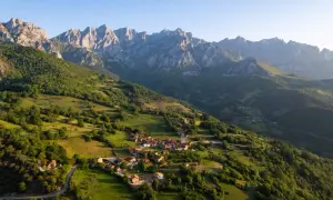 Un pueblo anidado en verdes colinas bajo los imponentes Picos de Europa. Descubre curiosidades de los Picos de Europa en este paisaje idílico.