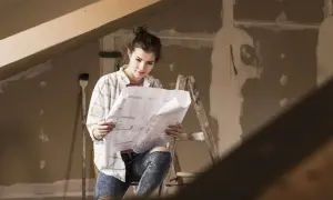 Młoda kobieta analizuje plany, planując inwestycję w obcym środku trwałym.