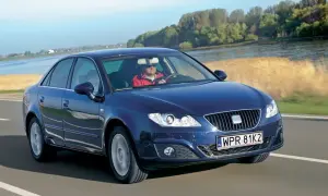 Ciemnoniebieski Seat Exeo 2.0 TDI jedzie drogą nad rzeką, kierowca w czerwonej kurtce.