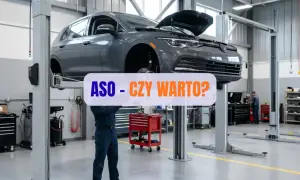 Mechanik w warsztacie podnosi samochód na podnośniku.