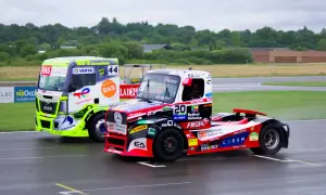 Deux camions de course s'affrontent sur le circuit. Le camion vert vif et le camion rouge et noir sont prêts pour le grand prix camion Nogaro.