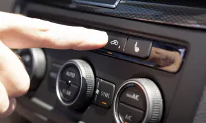 Finger trycker på knappen för acc bilens klimatanläggning.