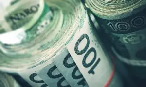 Zwijane banknoty 100 zł, symbolizujące fundusz rezerwy demograficznej, gotowe na przyszłe wyzwania.