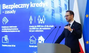 Mężczyzna w garniturze prezentuje zasady "Bezpiecznego kredytu" z dopłatą do rat. Program oferuje kredyt 2 procent dla singli i małżeństw.