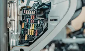 Panel z bezpiecznikami, gdzie są bezpieczniki w skuterze. Różnokolorowe bezpieczniki w skrzynce.