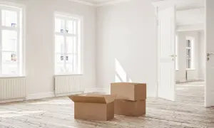 Appartement vide avec cartons, prêt à emménager. La lumière du soleil traverse les fenêtres, évoquant un nouveau départ, peut-être grâce à la loi Borloo.