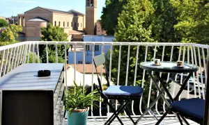 Balkon z widokiem na kościół, jak w Kafarnaum. Stolik z kawą i popielniczką.