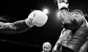 Un pugno in arrivo, un momento catturato da fotografi sportivi famosi. La polvere vola, l'intensità è palpabile.