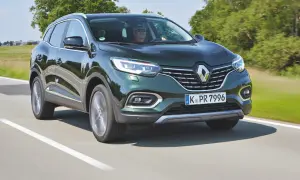 Zielony Renault Kadjar jedzie po drodze, za kierownicą mężczyzna w okularach.
