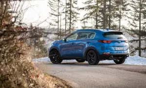 Niebieski Kia Sportage 3 na zimowej drodze. Zastanawiasz się, jakie opony do Kia Sportage 3 będą najlepsze?