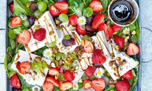 Sommarfräsch sallad med jordgubbar och fetaost, gröna druvor, nötter och en balsamico-dressing.
