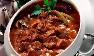 Herzhaftes Pfefferpotthast Rezept in einer Schüssel, garniert mit Petersilie und Gewürzgurken. Ein Klassiker der westfälischen Küche.