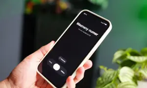 Dłoń trzyma smartfon z ekranem pokazującym "Nieznany numer" i opcje "Odrzuć", "Wiadomość", "Odbierz". Jak sprawdzić czyj to numer?