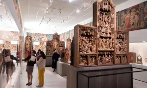 Besucher bestaunen im Cluny Museum detailreiche Holzschnitzereien und Wandteppiche.