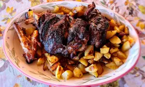 Un succulento agnello al forno con patate dorate, un piatto che profuma di tradizione e festa.