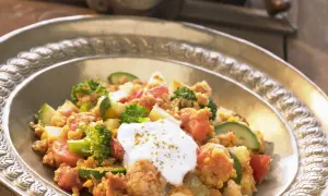 Herzhaftes Linsengericht mit Brokkoli, Zucchini und Tomaten, garniert mit einem Klecks Joghurt. Ein köstliches Beispiel für Linsen Rezepte.