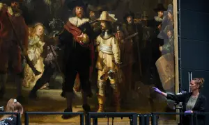 Restauratorin zeigt auf Rembrandts "die nachtwache maler", ein Meisterwerk der Malerei, das gerade untersucht wird.
