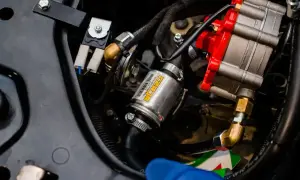 Uszkodzony map sensor lpg objawy: metalowy element z żółtą etykietą, przewody i czerwona część regulatora.