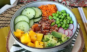 Kolorowy poke bowl z łososiem, mango, awokado, ogórkiem, edamame i rzodkiewką. Idealny przepis na zdrowy posiłek.