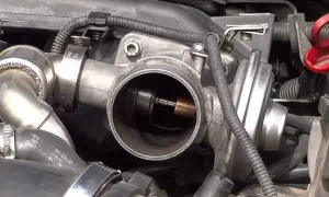 Cuerpo de acelerador de Peugeot, posible causa de DTC 0404. Se observa el mecanismo interno y la válvula.