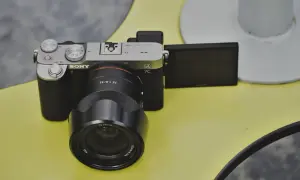 Aparat Sony a7c z obiektywem FE 1.8/35 na żółtym tle.