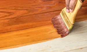 Aplicando barniz a madera de pino sin tratar, transformando su tono natural a un cálido color miel.