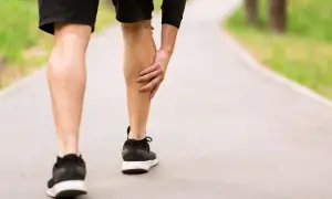 Un corridore si ferma, tenendosi il polpaccio. Potrebbe essere un segnale di un problema ipotonico, che significa una ridotta tonicità muscolare.
