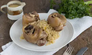 Drei deftige Eisbeine auf Sauerkraut, serviert mit Soße. Ein klassisches Eisbein Rezept für Genießer.