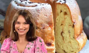 Uśmiechnięta kobieta w kwiecistej sukience obok puszystej, wilgotnej babki drożdżowej posypanej cukrem pudrem i czekoladą.