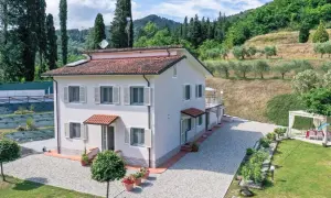 Villa unifamiliare immersa nel verde, con un ampio giardino, uliveto e vista collinare.