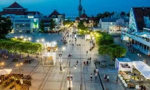 Wieczorny spacer po sopockim deptaku, gdzie tętni życiem **Sopot stare miasto**. Ludzie przechadzają się wśród iluminacji, tworząc niepowtarzalny klimat.