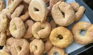 Un mucchio di taralli salati al vino bianco friabili, cosparsi di zucchero, pronti per essere gustati.