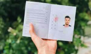 Międzynarodowe prawo jazdy z fotografią i pieczęciami, trzymane w dłoni.