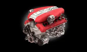 Motor V12 Ferrari rojo y blanco, ejemplo de los mejores motores gasolina, con colectores cromados y correas visibles.