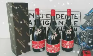 Tre bottiglie di birra Garlatti.Costa con decorazioni natalizie, una scatola e un albero di Natale sullo sfondo.