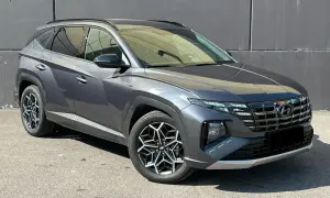 Szary Hyundai Tucson, jeden z najnowszych hyundai suv modele, z charakterystycznymi felgami i nowoczesnym designem, zaparkowany na tle szarej ściany.