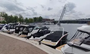 Łodzie zacumowane w porcie, z mostem w tle. Idealne miejsce, by zacząć planować, jak dojechać do Mikołajek i cieszyć się Mazurami.