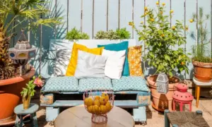 Un rincón perfecto para tus ideas chill out: un sofá de palets con cojines coloridos, plantas y faroles.