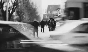 Zdjecia z analoga. Ludzie idący ulicą, rozmyte samochody i drzewa tworzą dynamiczną scenę miejską.