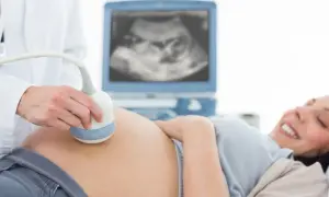 Radość przyszłej mamy podczas badania USG. Lekarz wykonuje badanie ultrasonograficzne, a na ekranie widać obraz dziecka.