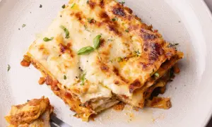 Une part de lasagne généreuse, dorée et gratinée, garnie de basilic frais. Une recette lasagne originale qui met l'eau à la bouche.