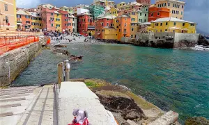 Une peluche attend sur les marches menant à la mer turquoise. Les maisons colorées de Boccadasse invitent à découvrir que faire à Gênes.