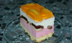 Pyszne ciasto z delicjami, warstwowe, z galaretką brzoskwiniową i owocami. Idealne na deser.
