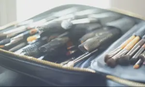 Une trousse ouverte révèle une collection de pinceaux de maquillage, prêts pour un cours de maquillage particulier.