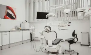 Nowoczesny gabinet stomatologiczny z fotelem, unitem i obrazem ust.